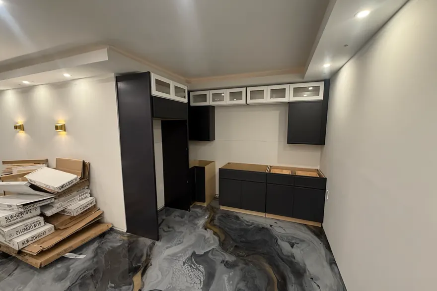 Kitchen mid-install with upper cabinets hung and wall sconces wired