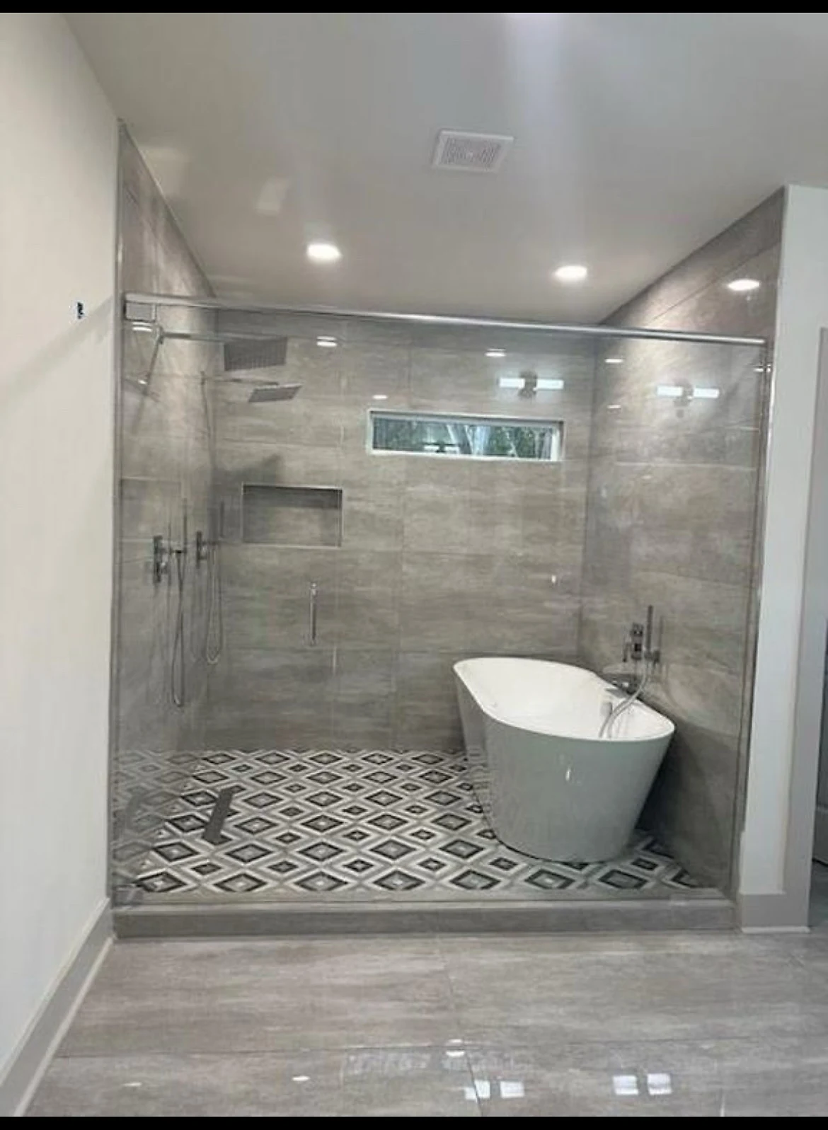 Finished owner's bath with a freestanding tub and full walk-in rain shower